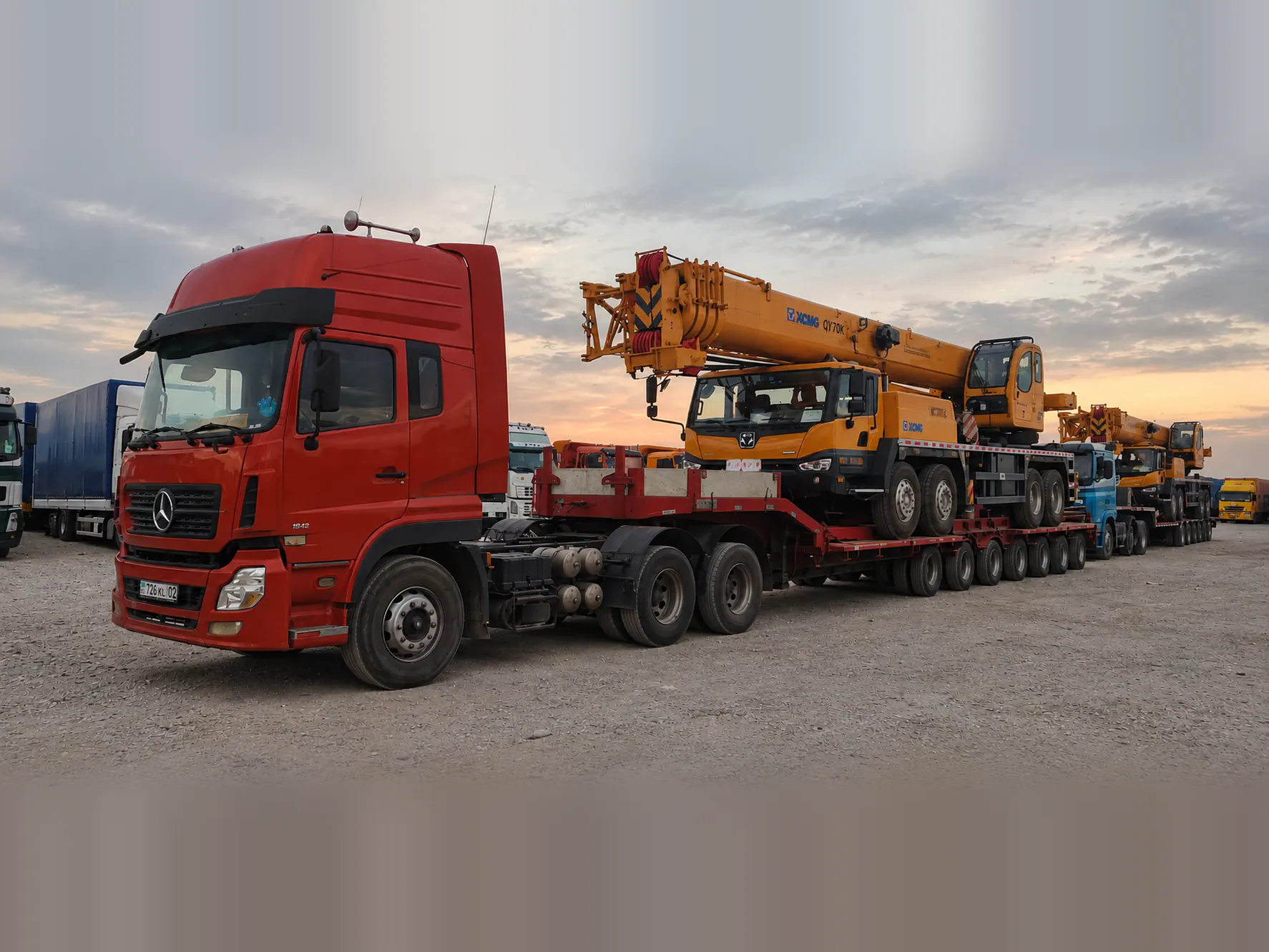 Седельный тягач с низкорамным тралом перевозит автокран XCMG